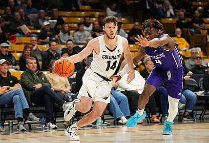 Dec 15, 2022; Boulder, Colorado, USA; Colorado Buffaloes guard Ethan Wright (14) drives past North Alabama Lions forward Bryson Dawkins (4) in the first half at the CU Events Center. Mandatory Credit: Ron Chenoy-USA TODAY Sports