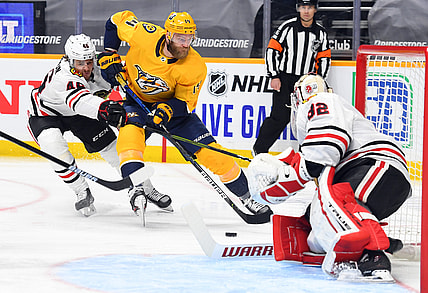 Jan 27, 2021; Nashville, Tennessee, USA; Nashville Predators defenseman Mattias Ekholm (14) skates the puck toward the net past Chicago Blackhawks defenseman Lucas Carlsson (46) during the first period at Bridgestone Arena. Mandatory Credit: Christopher Hanewinckel-USA TODAY Sports