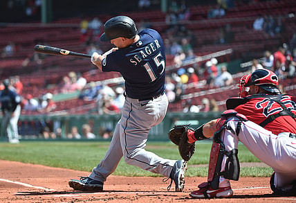 Apr 24, 2021; Boston, Massachusetts, USA;  Seattle Mariners third baseman Kyle Seager (15) hits an RBI single during the first inning against the Boston Red Sox at Fenway Park. Mandatory Credit: Bob DeChiara-USA TODAY Sports