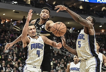 Nov 20, 2021; Milwaukee, Wisconsin, USA; Milwaukee Bucks forward Giannis Antetokounmpo (34) reaches for a rebound against Orlando Magic guard Jalen Suggs (4) and center Mo Bamba (5) in the second quarter at Fiserv Forum. Mandatory Credit: Benny Sieu-USA TODAY Sports