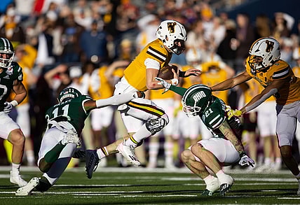 Dec 30, 2022; Tucson, AZ, USA; Wyoming Cowboys quarterback Andrew Peasley (6) runs the ball against Ohio Bobcats safety Tariq Drake (11) and cornerback Austin Brawley (21) in the first half of the 2022 Barstool Sports Arizona Bowl at Arizona Stadium. Mandatory Credit: Mark J. Rebilas-USA TODAY Sports