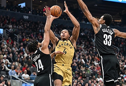 Feb 22, 2024; Toronto, Ontario, CAN;   Toronto Raptors forward Scottie Barnes (4) shoots the ball as Brooklyn Nets guard Cam Thomas (24) and center Nic Claxton (33) defend in the first half at Scotiabank Arena. Mandatory Credit: Dan Hamilton-USA TODAY Sports