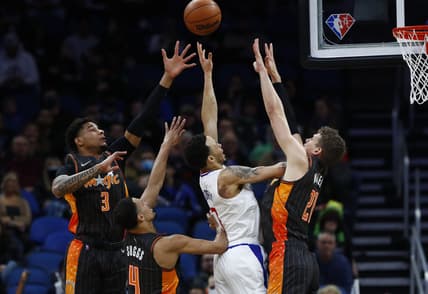 Jan 26, 2022; Orlando, Florida, USA; LA Clippers guard Amir Coffey (7) is tripled teamed by Orlando Magic forward Chuma Okeke (3), guard Jalen Suggs (4) and center Moritz Wagner (21) during the first quarter at Amway Center. Mandatory Credit: Kim Klement-USA TODAY Sports