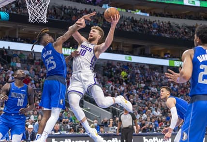 Mar 5, 2022; Dallas, Texas, USA; Dallas Mavericks forward Reggie Bullock (25) defends against Sacramento Kings forward Domantas Sabonis (10) during the second half at the American Airlines Center. Mandatory Credit: Jerome Miron-USA TODAY Sports