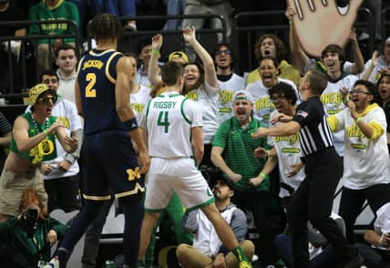 Oregon   s Brennan Rigsby, center, celebrates with Duck fans during the first half of their game against Michigan at Matthew Knight Arena in Eugene Saturday, Dec 2, 2023.