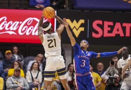 Jan 20, 2024; Morgantown, West Virginia, USA; West Virginia Mountaineers guard RaeQuan Battle (21) shoots over Kansas Jayhawks guard Dajuan Harris Jr. (3) during the first half at WVU Coliseum. Mandatory Credit: Ben Queen-USA TODAY Sports