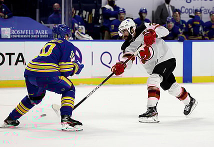Jan 30, 2021; Buffalo, New York, USA;  Buffalo Sabres defenseman Henri Jokiharju (10) tries to block a shot on goal by New Jersey Devils right wing Kyle Palmieri (21) during the third period at KeyBank Center. Mandatory Credit: Timothy T. Ludwig-USA TODAY Sports