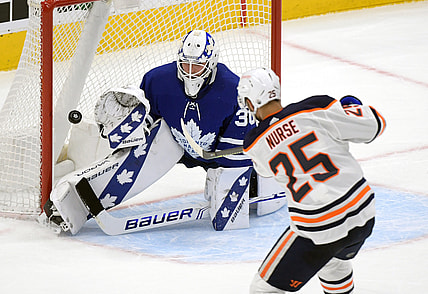Mar 29, 2021; Toronto, Ontario, CAN; Edmonton Oilers defenseman Darnell Nurse (25) scores the game winning goal past Toronto Maple Leafs goalie Michael Hutchinson (30) in overtime at Scotiabank Arena. Mandatory Credit: Dan Hamilton-USA TODAY Sports