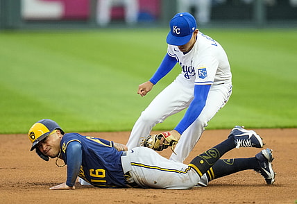 May 19, 2021; Kansas City, Missouri, USA; Milwaukee Brewers second baseman Kolten Wong (16) slides back to second base ahead of the tag by Kansas City Royals shortstop Nicky Lopez (8) during the first inning at Kauffman Stadium. Mandatory Credit: Jay Biggerstaff-USA TODAY Sports