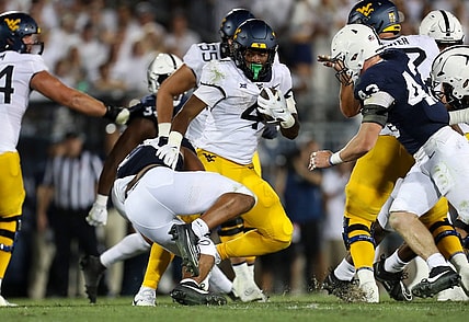 Sep 2, 2023; University Park, Pennsylvania, USA; West Virginia Mountaineers running back CJ Donaldson Jr. (4) runs the ball against the Penn State Nittany Lions during the fourth quarter at Beaver Stadium. Penn State won 38-15. Mandatory Credit: Matthew O'Haren-USA TODAY Sports