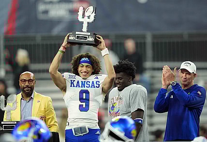 Dec 26, 2023; Phoenix, AZ, USA; Kansas Jayhawks quarterback Jason Bean (9) celebrates with the trophy after defeating the UNLV Rebels at Chase Field. Mandatory Credit: Joe Camporeale-USA TODAY Sports