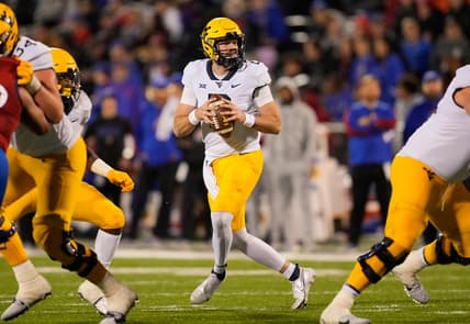 Nov 27, 2021; Lawrence, Kansas, USA; West Virginia Mountaineers quarterback Jarret Doege (2) drops back to pass against the Kansas Jayhawks during the first half at David Booth Kansas Memorial Stadium. Mandatory Credit: Jay Biggerstaff-USA TODAY Sports