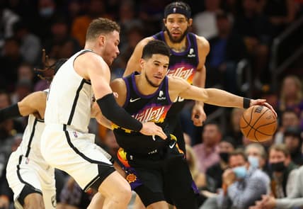 Feb 1, 2022; Phoenix, Arizona, USA; Phoenix Suns guard Devin Booker (1) dribbles the ball around Brooklyn Nets forward Blake Griffin (2) during the second half at Footprint Center. Mandatory Credit: Mark J. Rebilas-USA TODAY Sports