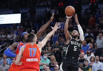 Nov 9, 2022; Oklahoma City, Oklahoma, USA; Milwaukee Bucks guard Jevon Carter (5) shoots as Oklahoma City Thunder forward Luguentz Dort (5) and forward Aleksej Pokusevski (17) defend during overtime at Paycom Center. Milwaukee won 136-132 in double overtime. Mandatory Credit: Alonzo Adams-USA TODAY Sports