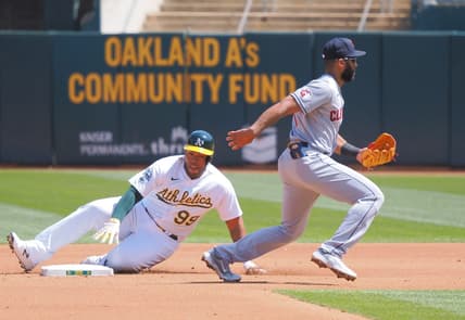 Apr 5, 2023; Oakland, California, USA; Oakland Athletics designated hitter Jesus Aguilar (99) safe at second base as Cleveland Guardians shortstop Amed Rosario (1) is unable to control the ball during the fourth inning at Oakland Coliseum. Mandatory Credit: Kelley L Cox-USA TODAY Sports