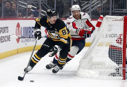 Jan 2, 2024; Pittsburgh, Pennsylvania, USA;  Pittsburgh Penguins center Sidney Crosby (87) moves the puck behind the net as Washington Capitals defenseman Nick Jensen (3) chases during the first period at PPG Paints Arena. Mandatory Credit: Charles LeClaire-USA TODAY Sports
