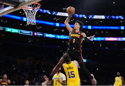 Mar 18, 2024; Los Angeles, California, USA; Atlanta Hawks forward Jalen Johnson (1) dunks the ball over Los Angeles Lakers guard Austin Reaves (15) in the first half at Crypto.com Arena. Mandatory Credit: Kirby Lee-USA TODAY Sports