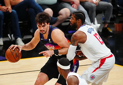 Jun 22, 2021; Phoenix, Arizona, USA; Phoenix Suns forward Dario Saric (left) against Los Angeles Clippers guard Paul George during game two of the Western Conference Finals for the 2021 NBA Playoffs at Phoenix Suns Arena. Mandatory Credit: Mark J. Rebilas-USA TODAY Sports