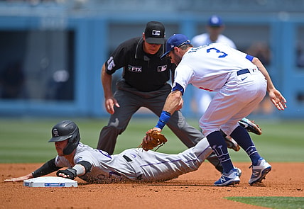 Jul 25, 2021; Los Angeles, California, USA;  Colorado Rockies shortstop Trevor Story (27) is tagged by Los Angeles Dodgers shortstop Chris Taylor (3) as he is caught in a run down play in the second inning at Dodger Stadium. Mandatory Credit: Jayne Kamin-Oncea-USA TODAY Sports