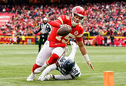 Dec 24, 2022; Kansas City, Missouri, USA; Kansas City Chiefs quarterback Patrick Mahomes (15) runs for a touchdown against Seattle Seahawks linebacker Jordyn Brooks (56) during the second half at GEHA Field at Arrowhead Stadium. Mandatory Credit: Jay Biggerstaff-USA TODAY Sports