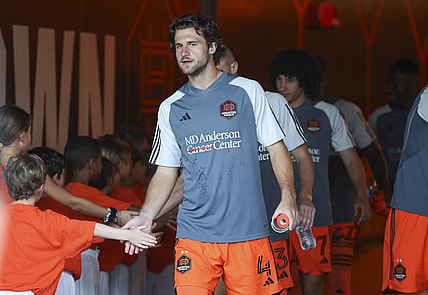 Aug 30, 2023; Houston, Texas, USA; Houston Dynamo FC defender Ethan Bartlow (4) and Dynamo FC players greet children in the tunnel before the match against the Columbus Crew SC at Shell Energy Stadium. Mandatory Credit: Troy Taormina-USA TODAY Sports