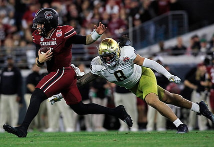Notre Dame Fighting Irish linebacker Marist Liufau (8) tries to sack the South Carolina Quarterback Spencer Rattler (7). The University of Notre Dame Fighting Irish took on the University of South Carolina Gamecocks in the TaxSlayer Gator Bowl game in Jacksonville, Florida's TIAA Bank Field Friday, December 30, 2022. The first half ended with South Carolina holding a 24 to 17 lead.