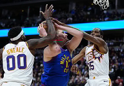 Mar 5, 2024; Denver, Colorado, USA; Phoenix Suns forward Kevin Durant (35) and forward Royce O'Neale (00) defend Denver Nuggets center Nikola Jokic (15) in the first half at Ball Arena. Mandatory Credit: Ron Chenoy-USA TODAY Sports