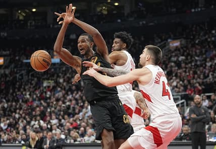Nov 28, 2022; Toronto, Ontario, CAN; Toronto Raptors forward Juancho Hernangomez (41) and forward Thaddeus Young (21) knock the ball away from Cleveland Cavaliers forward Evan Mobley (4) during the first half at Scotiabank Arena. Mandatory Credit: John E. Sokolowski-USA TODAY Sports