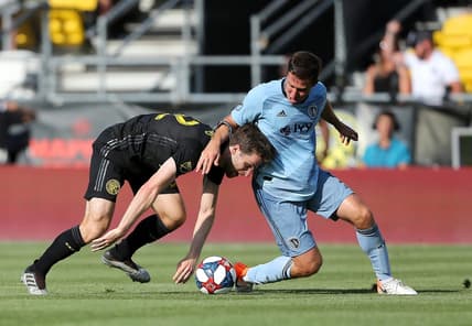 Jun 23, 2019; Columbus, OH, USA;  Columbus Crew forward Patrick Mullins (32) is taken down by Sporting Kansas City defender Matt Besler (5) during the first half at MAPFRE Stadium. Mandatory Credit: Joe Maiorana-USA TODAY Sports