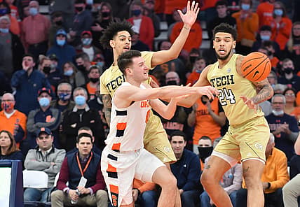 Feb 21, 2022; Syracuse, New York, USA; Syracuse Orange forward Jimmy Boeheim (0) makes a pass in front of Georgia Tech Yellow Jackets guard Michael Devoe and center Rodney Howard (24) in the first half at the Carrier Dome. Mandatory Credit: Mark Konezny-USA TODAY Sports