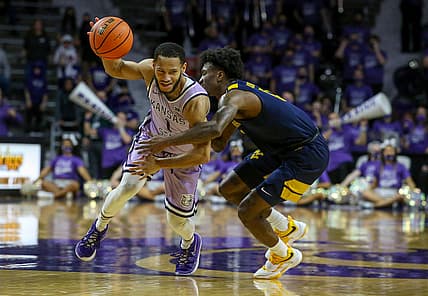 Feb 14, 2022; Manhattan, Kansas, USA; Kansas State Wildcats guard Markquis Nowell (1) dribbles against West Virginia Mountaineers guard Kedrian Johnson (0) during the second half at Bramlage Coliseum. Mandatory Credit: Scott Sewell-USA TODAY Sports