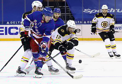 Feb 10, 2021; New York, New York, USA;  Alexis Lafreniere #13 of the New York Rangers and Craig Smith #12 of the Boston Bruins battle for the puck during the first period at Madison Square Garden. Mandatory Credit: Bruce Bennett/Pool Photo-USA TODAY Sports