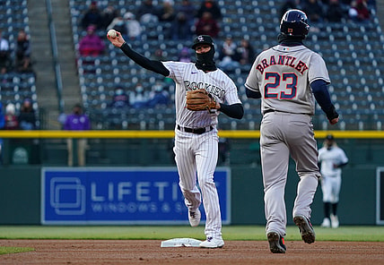 Apr 20, 2021; Denver, Colorado, USA; Colorado Rockies second baseman Ryan McMahon (24) turns a double play on Houston Astros left fielder Michael Brantley (23) in the first inning against the Houston Astros at Coors Field. Mandatory Credit: Ron Chenoy-USA TODAY Sports