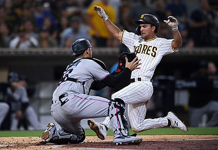 Aug 9, 2021; San Diego, California, USA; San Diego Padres second baseman Adam Frazier (right) is tagged out at home by Miami Marlins catcher Alex Jackson (23) during the third inning at Petco Park. Mandatory Credit: Orlando Ramirez-USA TODAY Sports