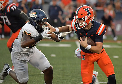 Sep 2, 2023; Champaign, Illinois, USA;  Illinois Fighting Illini quarterback Luke Altmyer (9) puts a hand to the helmet of Toledo Rockets linebacker CJ Wilson Jr. (33) on a run during the first half at Memorial Stadium. Mandatory Credit: Ron Johnson-USA TODAY Sports