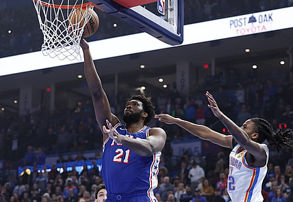 Nov 25, 2023; Oklahoma City, Oklahoma, USA; Philadelphia 76ers center Joel Embiid (21) shoots as Oklahoma City Thunder guard Cason Wallace (22) defends during the first quarter at Paycom Center. Mandatory Credit: Alonzo Adams-USA TODAY Sports