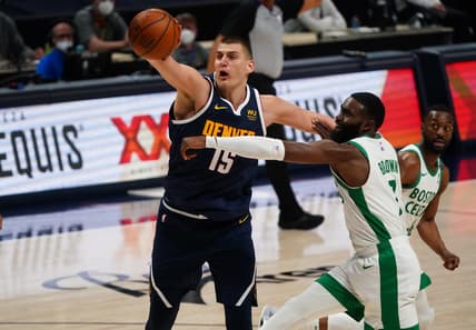Apr 11, 2021; Denver, Colorado, USA; Denver Nuggets center Nikola Jokic (15) and Boston Celtics guard Jaylen Brown (7) reach for the ball in the third quarter at Ball Arena. Mandatory Credit: Ron Chenoy-USA TODAY Sports
