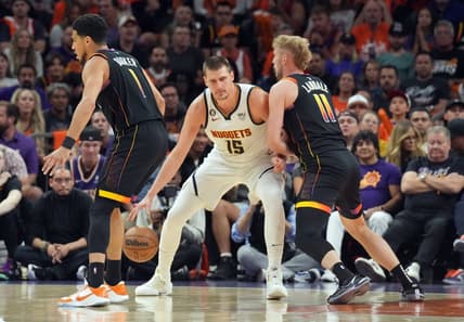 May 11, 2023; Phoenix, Arizona, USA; Denver Nuggets center Nikola Jokic (15) dribbles against Phoenix Suns guard Devin Booker (1) and Phoenix Suns center Jock Landale (11) during the first half of game six of the 2023 NBA playoffs at Footprint Center. Mandatory Credit: Joe Camporeale-USA TODAY Sports