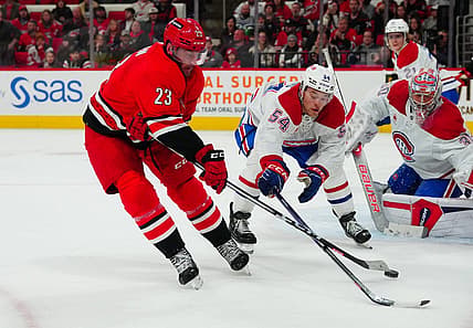 Dec 28, 2023; Raleigh, North Carolina, USA; Carolina Hurricanes right wing Stefan Noesen (23) ties to get his shot by Montreal Canadiens defenseman Jordan Harris (54) during the third period at PNC Arena. Mandatory Credit: James Guillory-USA TODAY Sports