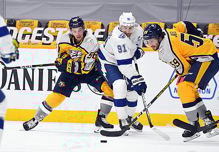 Feb 8, 2021; Nashville, Tennessee, USA; Tampa Bay Lightning center Steven Stamkos (91) works to get the puck against Nashville Predators left wing Erik Haula (56) and Nashville Predators defenseman Roman Josi (59) during the third period at Bridgestone Arena. Mandatory Credit: Christopher Hanewinckel-USA TODAY Sports