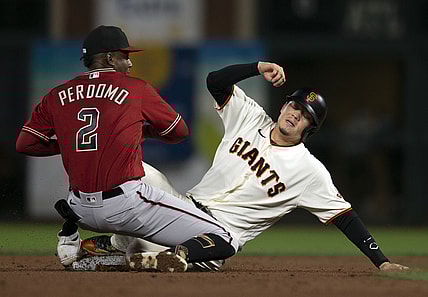 Sep 29, 2021; San Francisco, California, USA; Arizona Diamondbacks shortstop Geraldo Perdomo (2) takes the relay in time to force out San Francisco Giants first baseman Wilmer Flores (right) at second base during the second inning at Oracle Park. Mandatory Credit: D. Ross Cameron-USA TODAY Sports