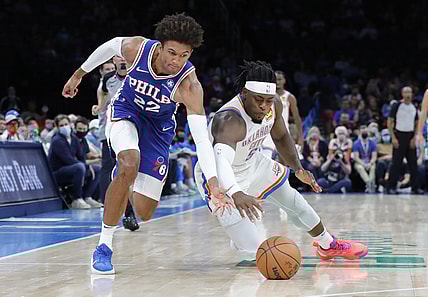 Oct 24, 2021; Oklahoma City, Oklahoma, USA; Philadelphia 76ers guard Matisse Thybulle (22) and Oklahoma City Thunder forward Luguentz Dort (5) dive for a loose ball during the second quarter at Paycom Center. Mandatory Credit: Alonzo Adams-USA TODAY Sports
