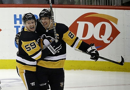 Feb 15, 2022; Pittsburgh, Pennsylvania, USA;  Pittsburgh Penguins left wing Jake Guentzel (59) congratulates center Sidney Crosby (87) after Crosby scored his 500th career NHL goal against the Philadelphia Flyers during the first period at PPG Paints Arena. Mandatory Credit: Charles LeClaire-USA TODAY Sports