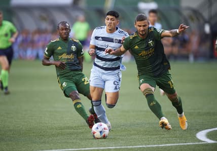 Jun 19, 2021; Portland, Oregon, USA; Portland Timbers defender Dario Zuparic (13) defends Sporting Kansas City forward Alan Pulido (9) during the first half at Providence Park. Mandatory Credit: Troy Wayrynen-USA TODAY Sports