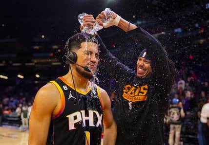 Dec 17, 2022; Phoenix, Arizona, USA; Phoenix Suns guard Devin Booker has water dumped on him by teammate Damion Lee after defeating the New Orleans Pelicans at Footprint Center. Mandatory Credit: Mark J. Rebilas-USA TODAY Sports