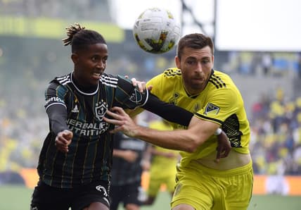 Sep 10, 2022; Nashville, Tennessee, USA; Los Angeles Galaxy forward Kevin Cabral (9) and Nashville SC defender Dave Romney (4) battle for a loose ball during the first half at Geodis Park. Mandatory Credit: Christopher Hanewinckel-USA TODAY Sports