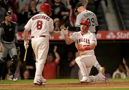Jun 26, 2023; Anaheim, California, USA; Los Angeles Angels center fielder Mike Trout (27) celebrates with first baseman Mike Moustakas (8) after scoring from third on a wild pitch by Chicago White Sox relief pitcher Aaron Bummer (39) to win the game in the ninth inning at Angel Stadium. Mandatory Credit: Jayne Kamin-Oncea-USA TODAY Sports