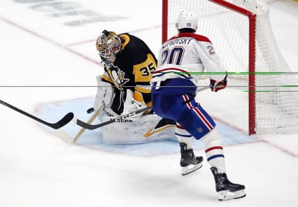Jan 27, 2024; Pittsburgh, Pennsylvania, USA;  Pittsburgh Penguins goaltender Tristan Jarry (35) makes a save against Montreal Canadiens left wing Juraj Slafkovsky (20) in overtime at PPG Paints Arena. The Penguins won 3-2 in overtime. Mandatory Credit: Charles LeClaire-USA TODAY Sports