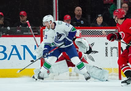 Feb 6, 2024; Raleigh, North Carolina, USA; Vancouver Canucks center Elias Lindholm (23) tips the puck past Carolina Hurricanes goaltender Pyotr Kochetkov (52) for a goal during the first period at PNC Arena. Mandatory Credit: James Guillory-USA TODAY Sports