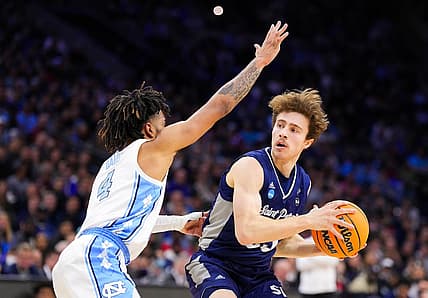 Mar 27, 2022; Philadelphia, PA, USA; St. Peters Peacocks guard Doug Edert (25) controls the ball as North Carolina Tar Heels guard R.J. Davis (4) defends during the first half in the finals of the East regional of the men's college basketball NCAA Tournament at Wells Fargo Center. Mandatory Credit: Mitchell Leff-USA TODAY Sports
